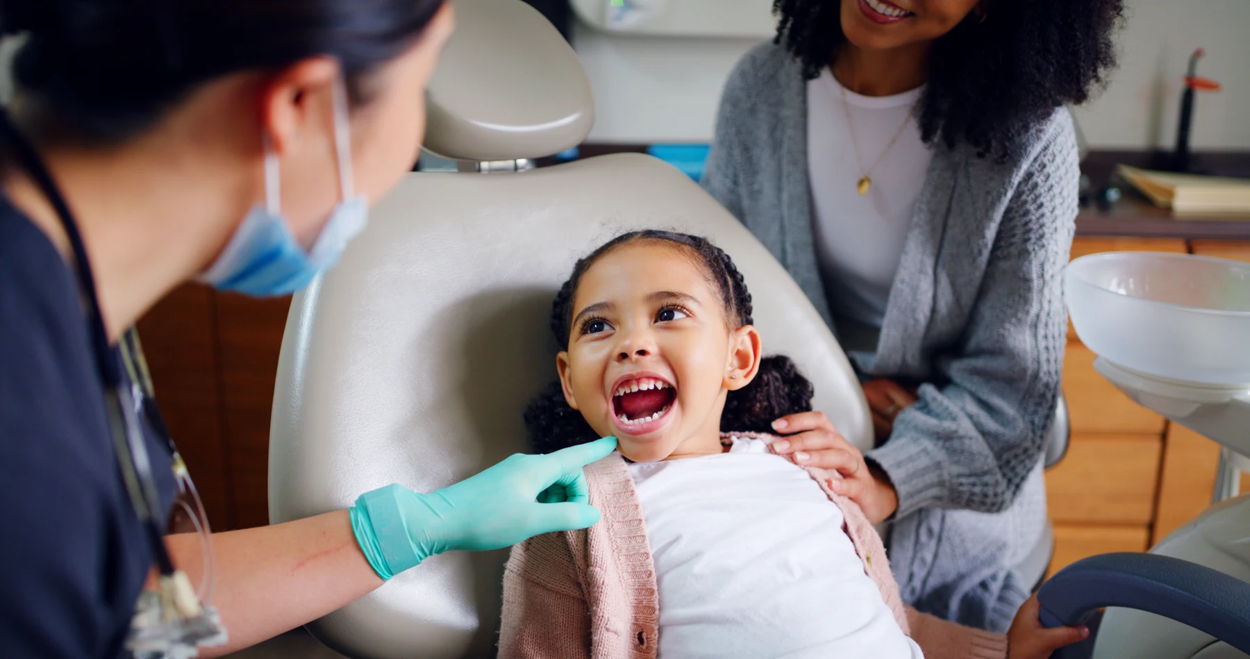 A child receiving a dental examination with a parent nearby