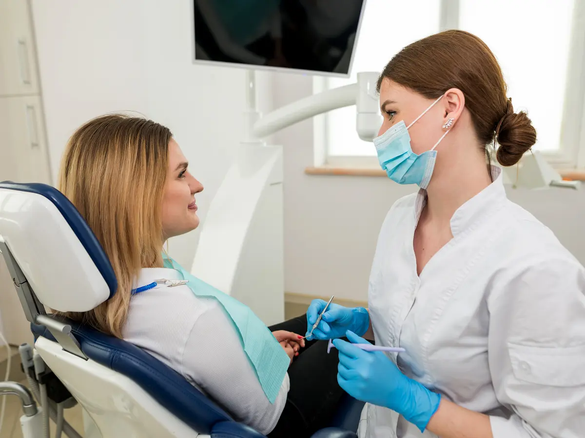 A patient speaking with her dental clinician before preventive care