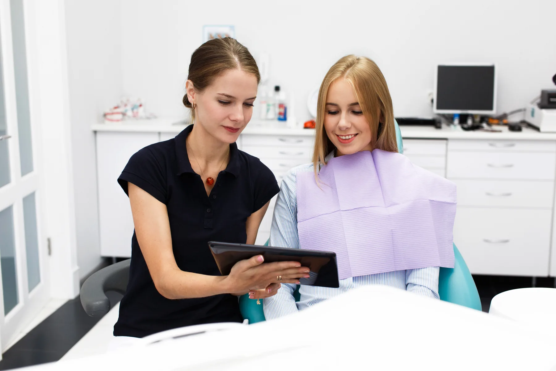 A dentist reviewing examination findings with an adult patient