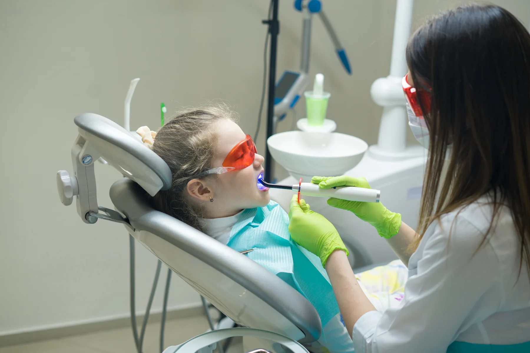 A child receiving protective dental treatment with a curing light