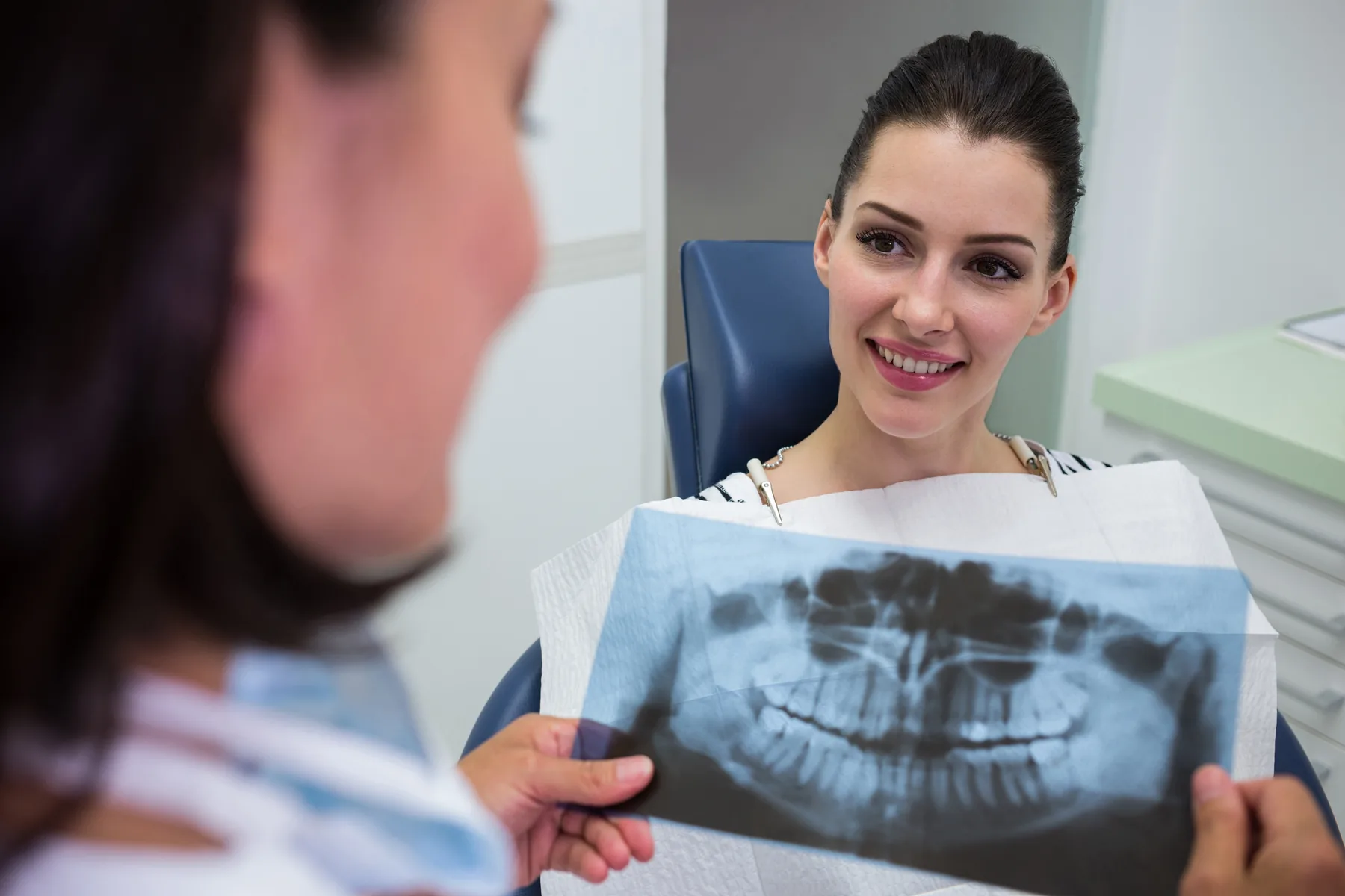 A dentist explaining a digital dental X-ray to a patient